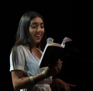 Rupi Kaur lendo um livro em pé