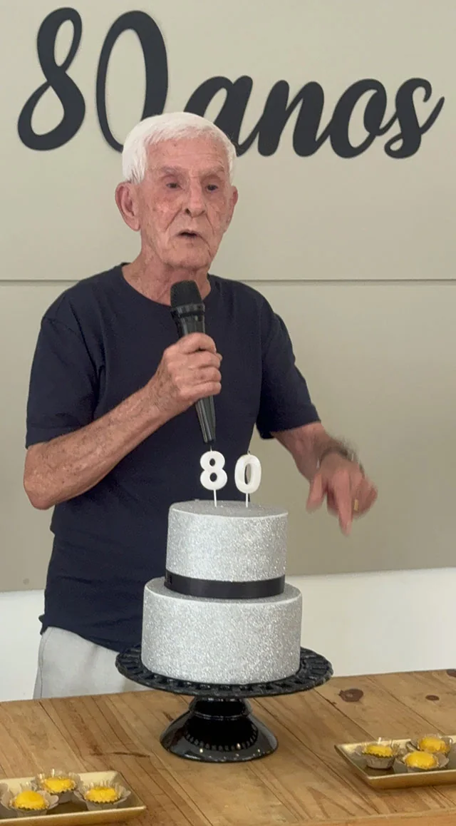Josué dos Santos falando ao microfone durante a celebração de seus 80 anos