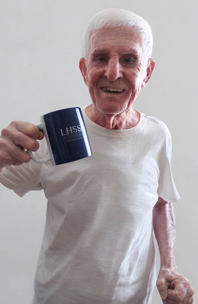 Josué dos Santos sorrindo e segurando uma caneca